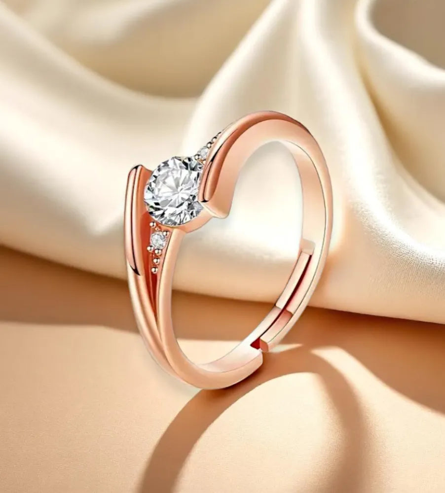Rose gold ring with a diamond on a beige fabric background