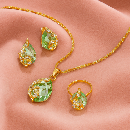 4pcs Teardrop Rhinestone Jewelry Set – Necklace, Earrings & Ring - Gold jewelry set with green teardrop-shaped gemstones on a beige surface