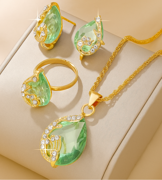 4pcs Teardrop Rhinestone Jewelry Set – Necklace, Earrings & Ring - Gold jewelry set with green teardrop-shaped gemstones on a beige surface