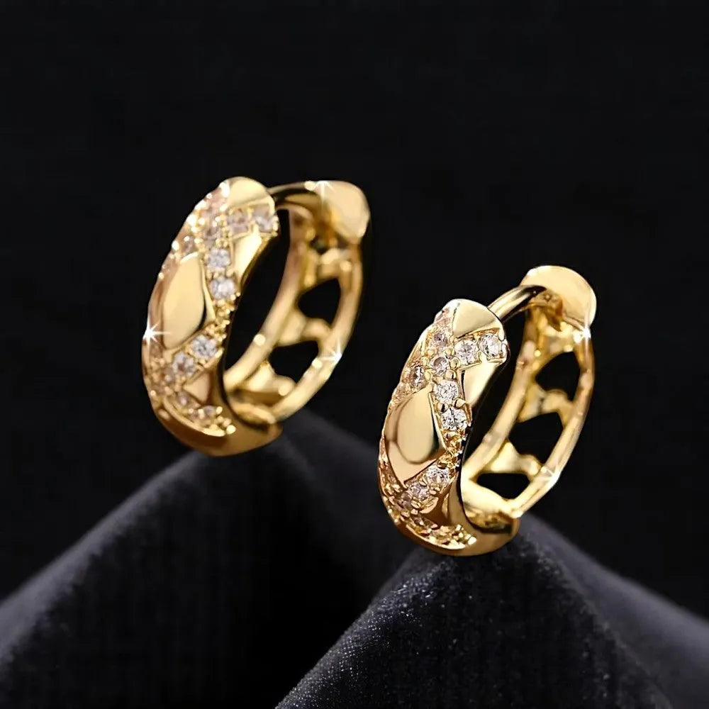 Gold hoop earrings with diamond accents on a black background
