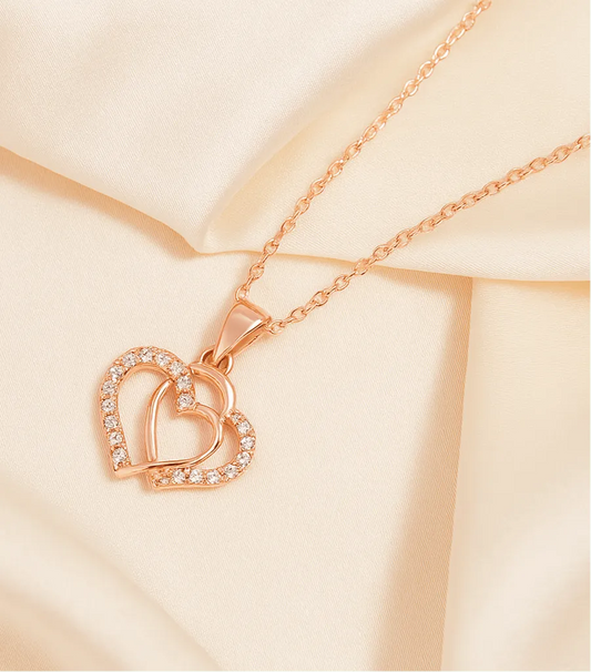 Rose gold necklace with a heart-shaped pendant on a beige background