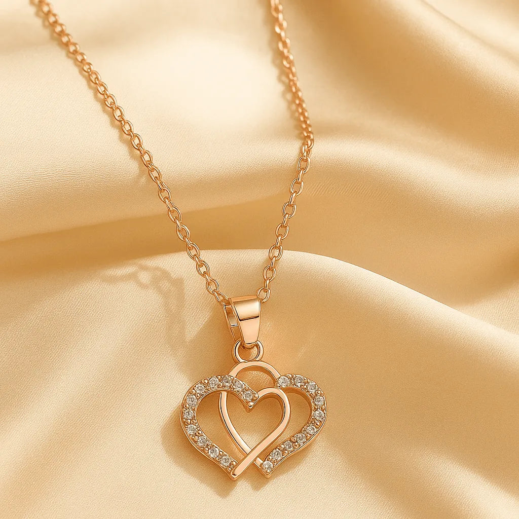 Rose gold necklace with a double heart pendant on a beige fabric background