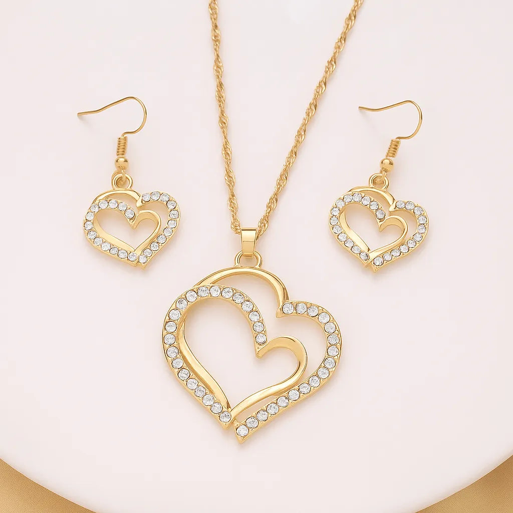 Gold heart-shaped necklace and earrings on a person - Double Heart Pendant Jewelry Set – Necklace & Earrings for Women - miraye.net