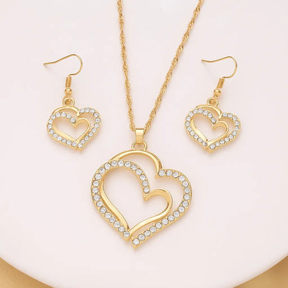 Gold heart-shaped necklace and earrings on a person - Double Heart Pendant Jewelry Set – Necklace & Earrings for Women - miraye.net