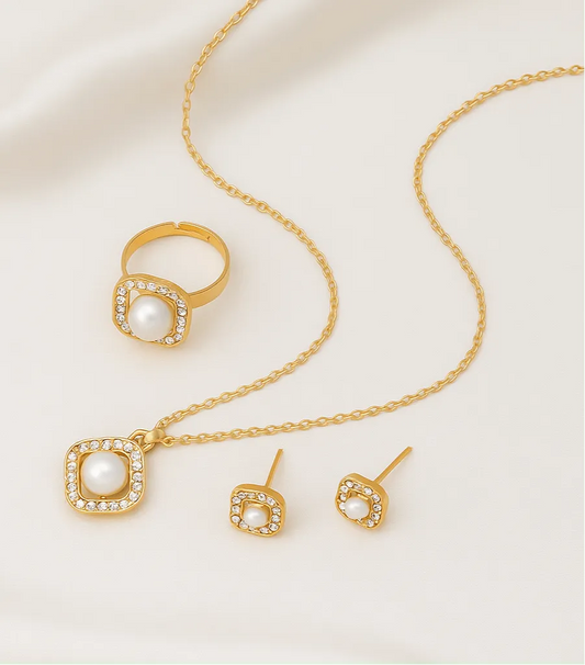 Gold jewelry set with necklace, ring, and earrings on a light background