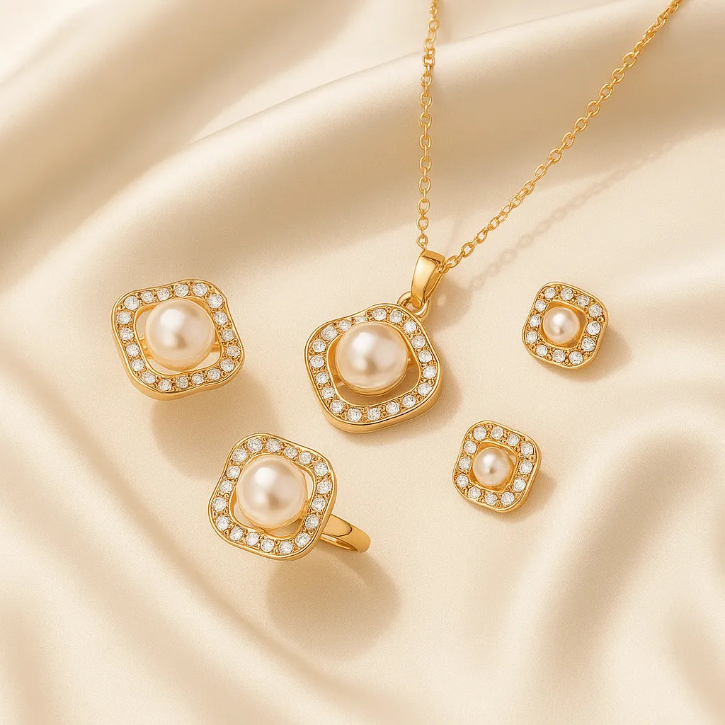Gold jewelry set with pearls on a beige fabric background