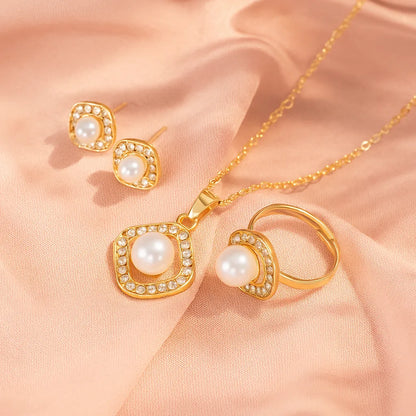 Gold jewelry set with pearls on a soft pink fabric background