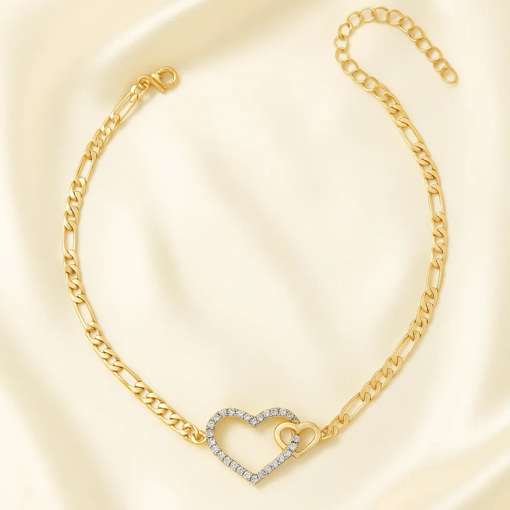 Gold bracelet with a heart-shaped clasp on a light beige background