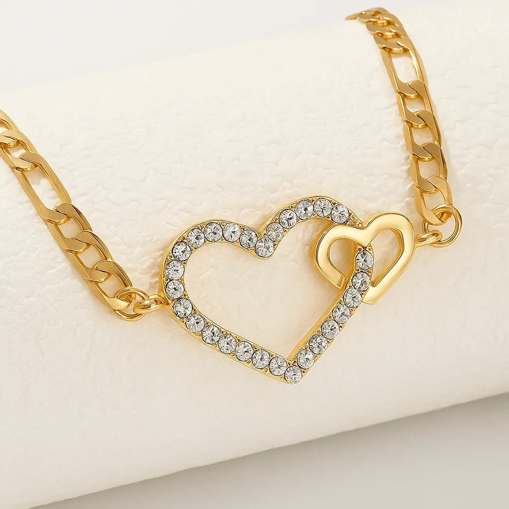 Gold bracelet with a heart-shaped clasp on a beige background